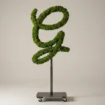 Monogram letter G topiary in Flowing script style, packed with green moss, on an adjustable stand