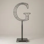 Monogram letter G topiary frame in Roman style, bare galvanized steel on an adjustable stand