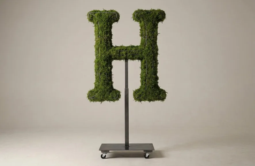 Monogram letter H topiary in Cinzel style, packed with green moss, on an adjustable stand