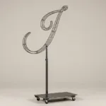 Monogram letter I topiary frame in Flowing script style, bare galvanized steel on an adjustable stand