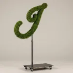 Monogram letter I topiary in Flowing script style, packed with green moss, on an adjustable stand