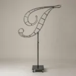 Monogram letter I topiary frame in Script style, bare galvanized steel on an adjustable stand