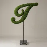 Monogram letter I topiary in Script style, packed with green moss, on an adjustable stand
