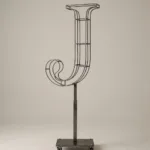 Monogram letter J topiary frame in Cinzel style, bare galvanized steel on an adjustable stand