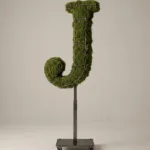 Monogram letter J topiary in Cinzel style, packed with green moss, on an adjustable stand