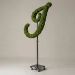 Monogram letter J topiary in Flowing script style, packed with green moss, on an adjustable stand