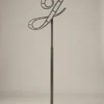 Monogram letter J topiary frame in Script style, bare galvanized steel on an adjustable stand