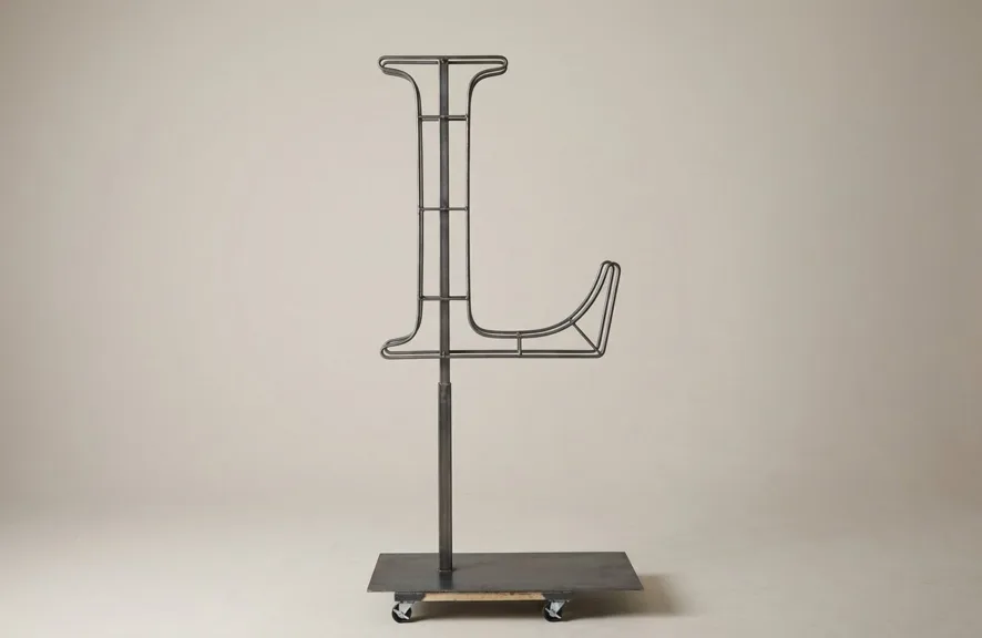 Monogram letter L topiary frame in Cinzel style, bare galvanized steel on an adjustable stand