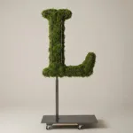 Monogram letter L topiary in Cinzel style, packed with green moss, on an adjustable stand