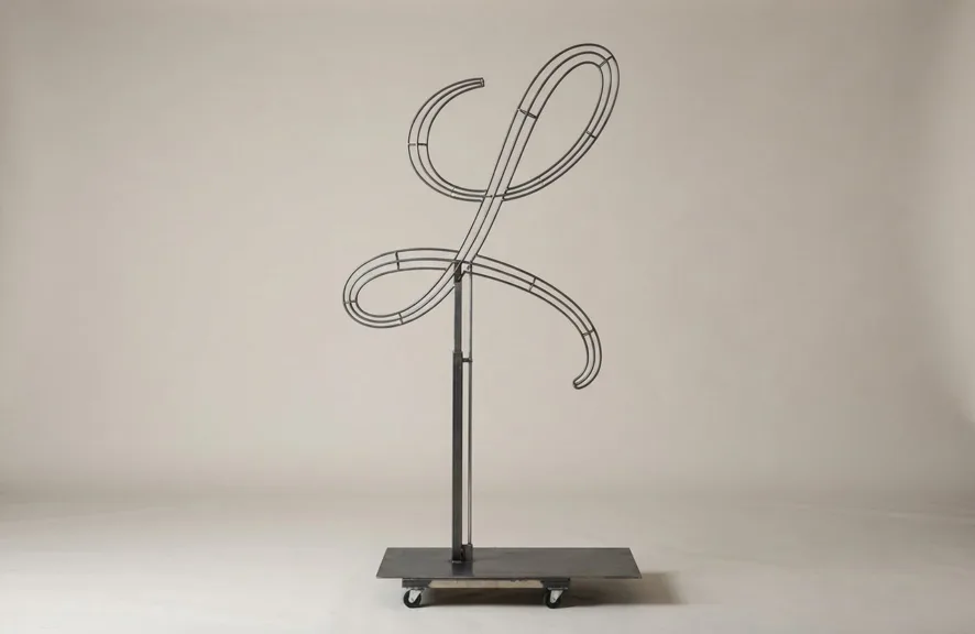 Monogram letter L topiary frame in Flowing script style, bare galvanized steel on an adjustable stand