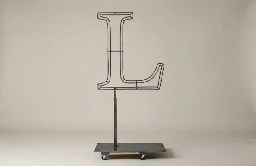 Monogram letter L topiary frame in Roman style, bare galvanized steel on an adjustable stand