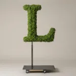 Monogram letter L topiary in Roman style, packed with green moss, on an adjustable stand