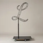 Monogram letter L topiary frame in Script style, bare galvanized steel on an adjustable stand