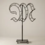 Monogram letter M topiary frame in Custom style, bare galvanized steel on an adjustable stand