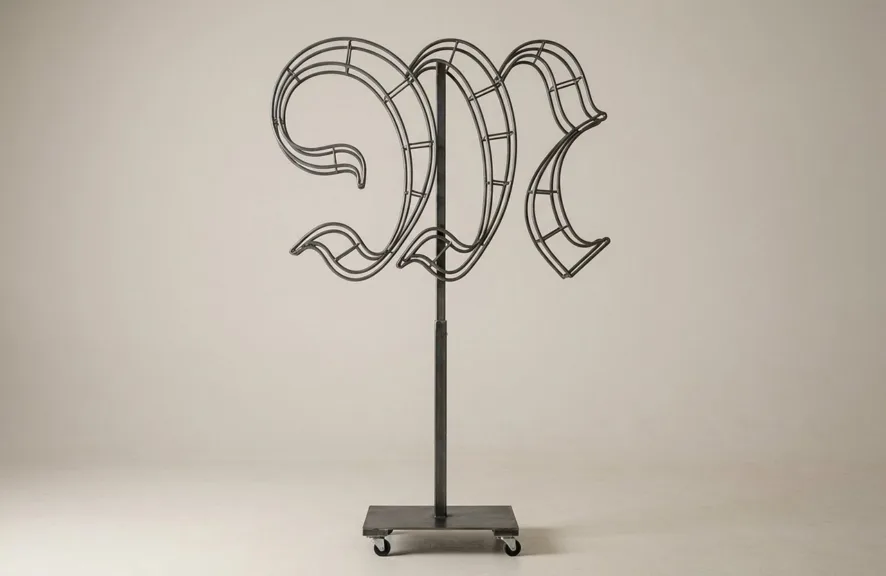 Monogram letter M topiary frame in Custom style, bare galvanized steel on an adjustable stand