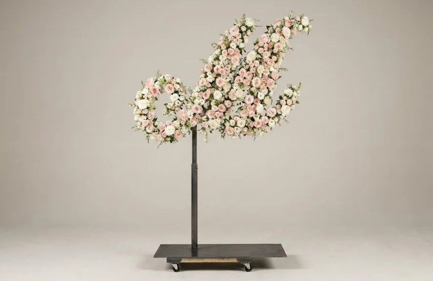 Monogram letter M topiary in script style, covered in pink and white roses