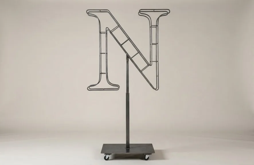 Monogram letter N topiary frame in Cinzel style, bare galvanized steel on an adjustable stand