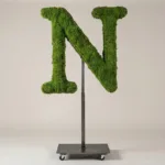 Monogram letter N topiary in Cinzel style, packed with green moss, on an adjustable stand