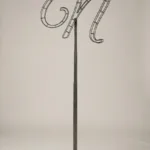 Monogram letter N topiary frame in Flowing script style, bare galvanized steel on an adjustable stand