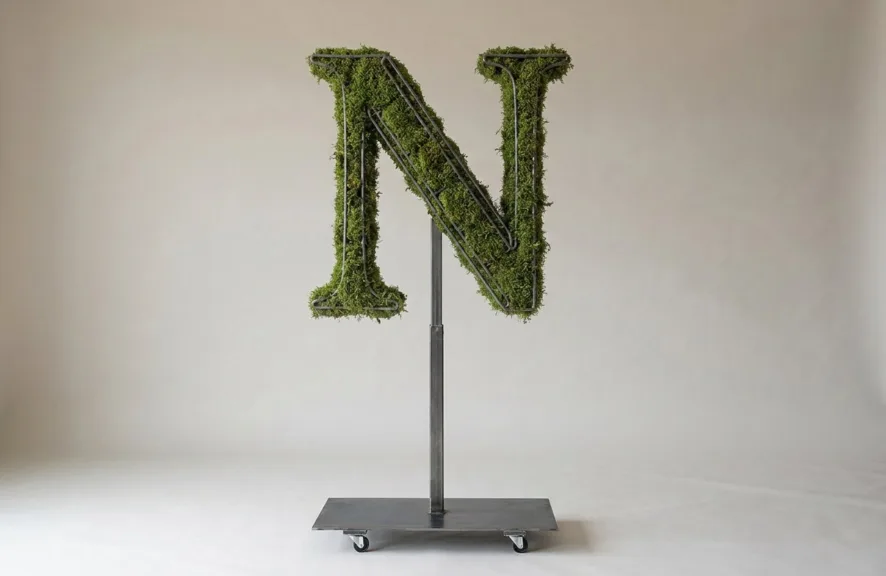 Monogram letter N topiary in Roman style, packed with green moss, on an adjustable stand