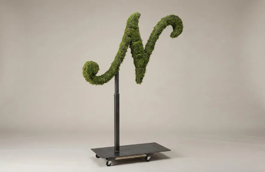 Monogram letter N topiary in Script style, packed with green moss, on an adjustable stand