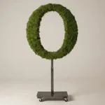 Monogram letter O topiary in Cinzel style, packed with green moss, on an adjustable stand
