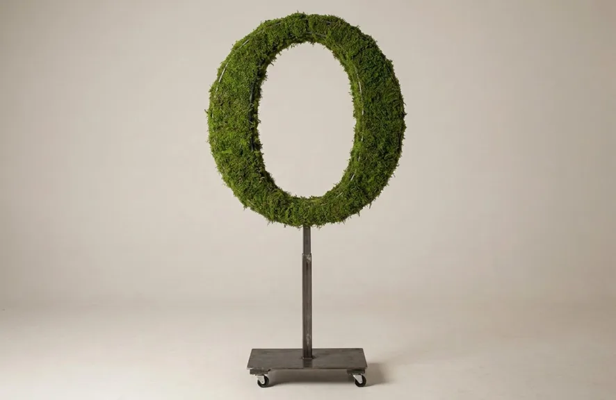 Monogram letter O topiary in Cinzel style, packed with green moss, on an adjustable stand