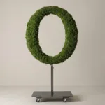 Monogram letter O topiary in Roman style, packed with green moss, on an adjustable stand