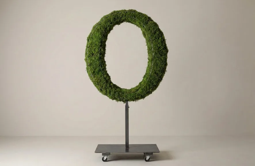 Monogram letter O topiary in Roman style, packed with green moss, on an adjustable stand