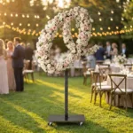 Monogram letter O topiary covered in flowers as a photo backdrop at a garden wedding