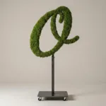 Monogram letter O topiary in Script style, packed with green moss, on an adjustable stand