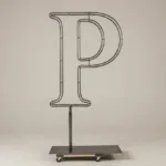Monogram letter P topiary frame in Cinzel style, bare galvanized steel on an adjustable stand