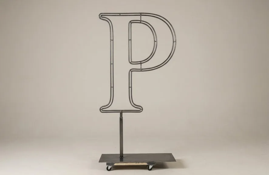 Monogram letter P topiary frame in Cinzel style, bare galvanized steel on an adjustable stand
