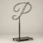 Monogram letter P topiary frame in Flowing script style, bare galvanized steel on an adjustable stand