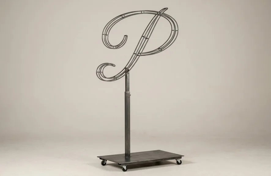Monogram letter P topiary frame in Flowing script style, bare galvanized steel on an adjustable stand