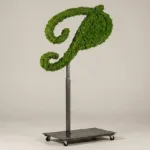 Monogram letter P topiary in Flowing script style, packed with green moss, on an adjustable stand