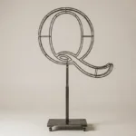 Monogram letter Q topiary frame in Cinzel style, bare galvanized steel on an adjustable stand