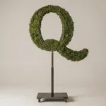 Monogram letter Q topiary in Cinzel style, packed with green moss, on an adjustable stand