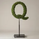 Monogram letter Q topiary in Script style, packed with green moss, on an adjustable stand