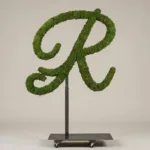 Monogram letter R topiary in Flowing script style, packed with green moss, on an adjustable stand