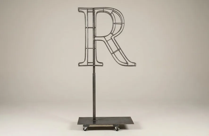 Monogram letter R topiary frame in Roman style, bare galvanized steel on an adjustable stand