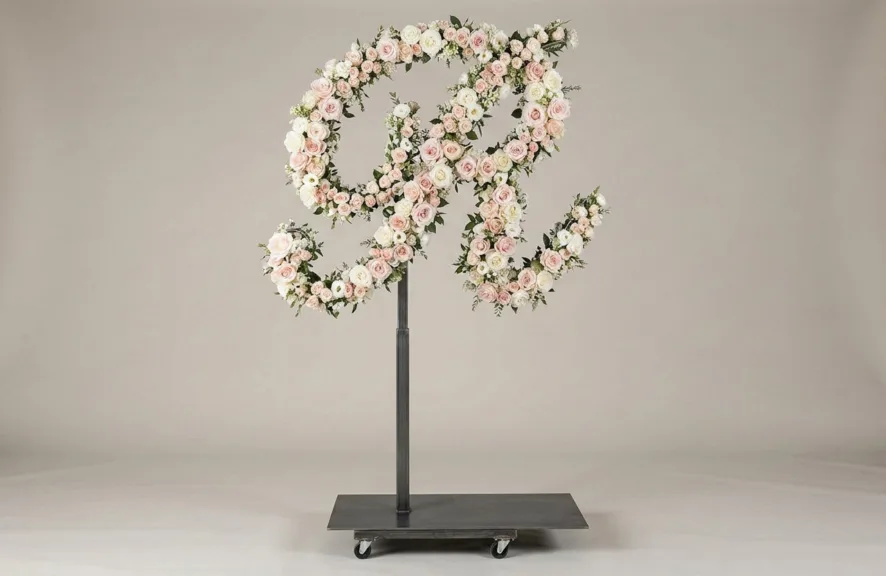 Monogram letter R topiary in script style, covered in pink and white roses