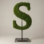 Monogram letter S topiary in Cinzel style, packed with green moss, on an adjustable stand