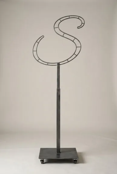 Monogram letter S topiary frame in Flowing script style, bare galvanized steel on an adjustable stand