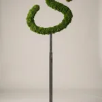 Monogram letter S topiary in Flowing script style, packed with green moss, on an adjustable stand
