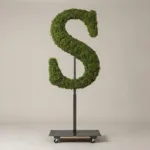 Monogram letter S topiary in Roman style, packed with green moss, on an adjustable stand