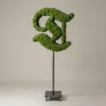 Monogram letter T topiary in Custom style, packed with green moss, on an adjustable stand