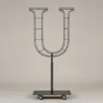 Monogram letter U topiary frame in Cinzel style, bare galvanized steel on an adjustable stand