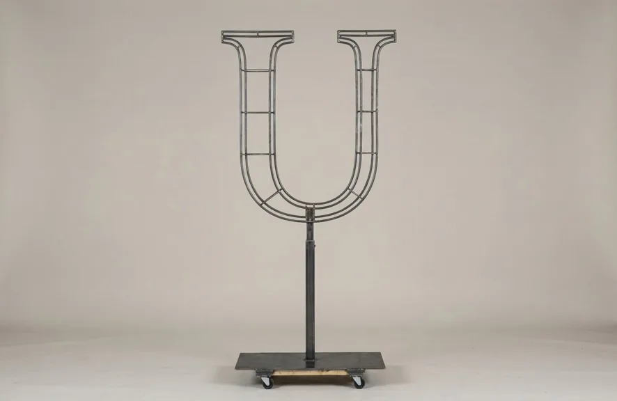 Monogram letter U topiary frame in Cinzel style, bare galvanized steel on an adjustable stand
