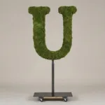Monogram letter U topiary in Cinzel style, packed with green moss, on an adjustable stand